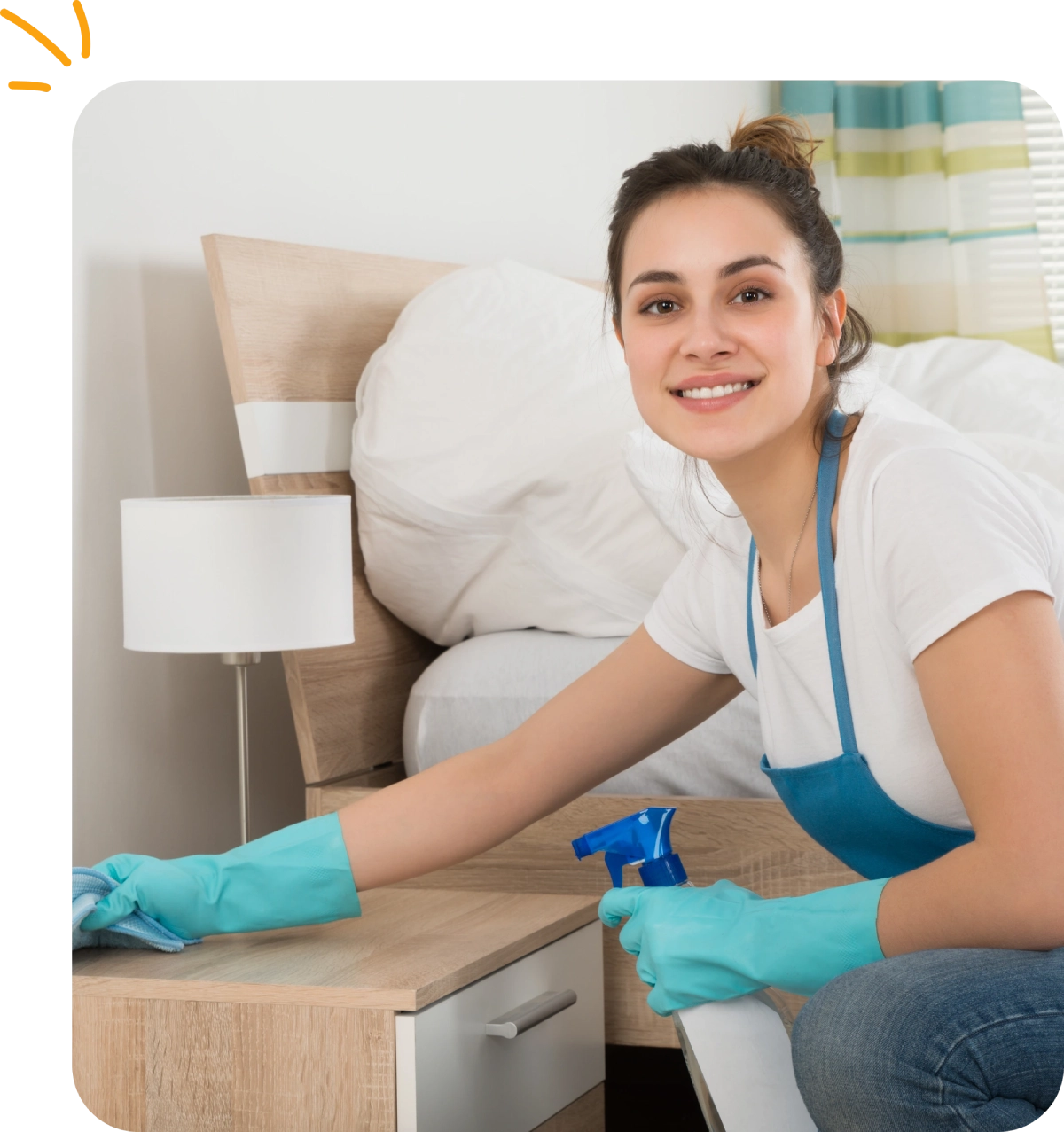 Maid cleaning a bedroom nightstand.