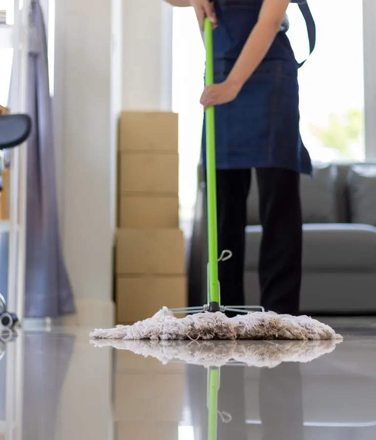 Person mopping floor with green mop.